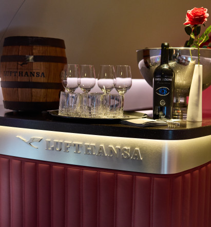 A red bar with the Lufthansa logo in the rear fuselage of the Super Star; on top: a Lufthansa beer keg and a red First Class Rose